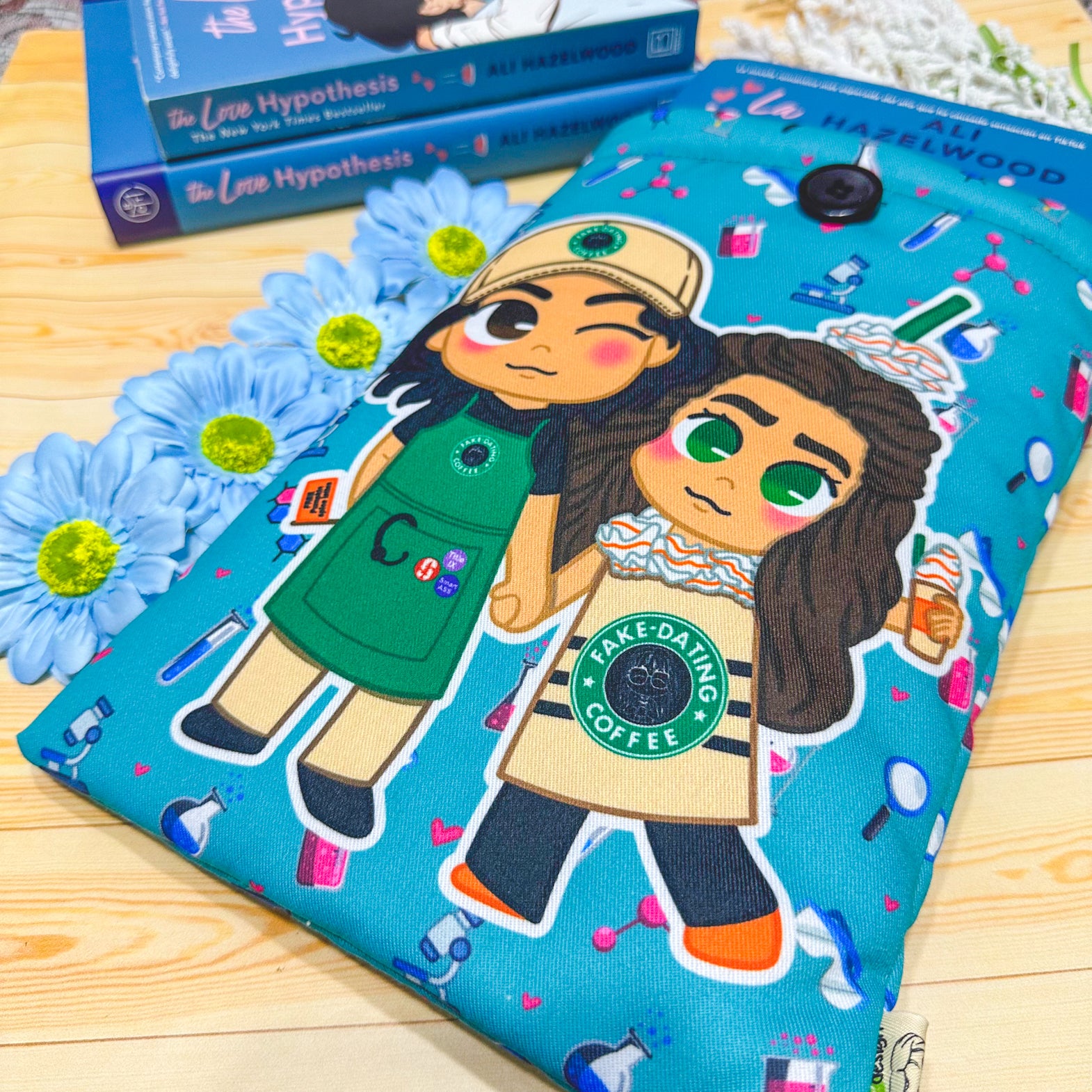 A padded book sleeve with vibrant designs inspired by Ali Hazelwood's novels, featuring romantic and STEM-themed illustrations of chibi-style characters. fanart